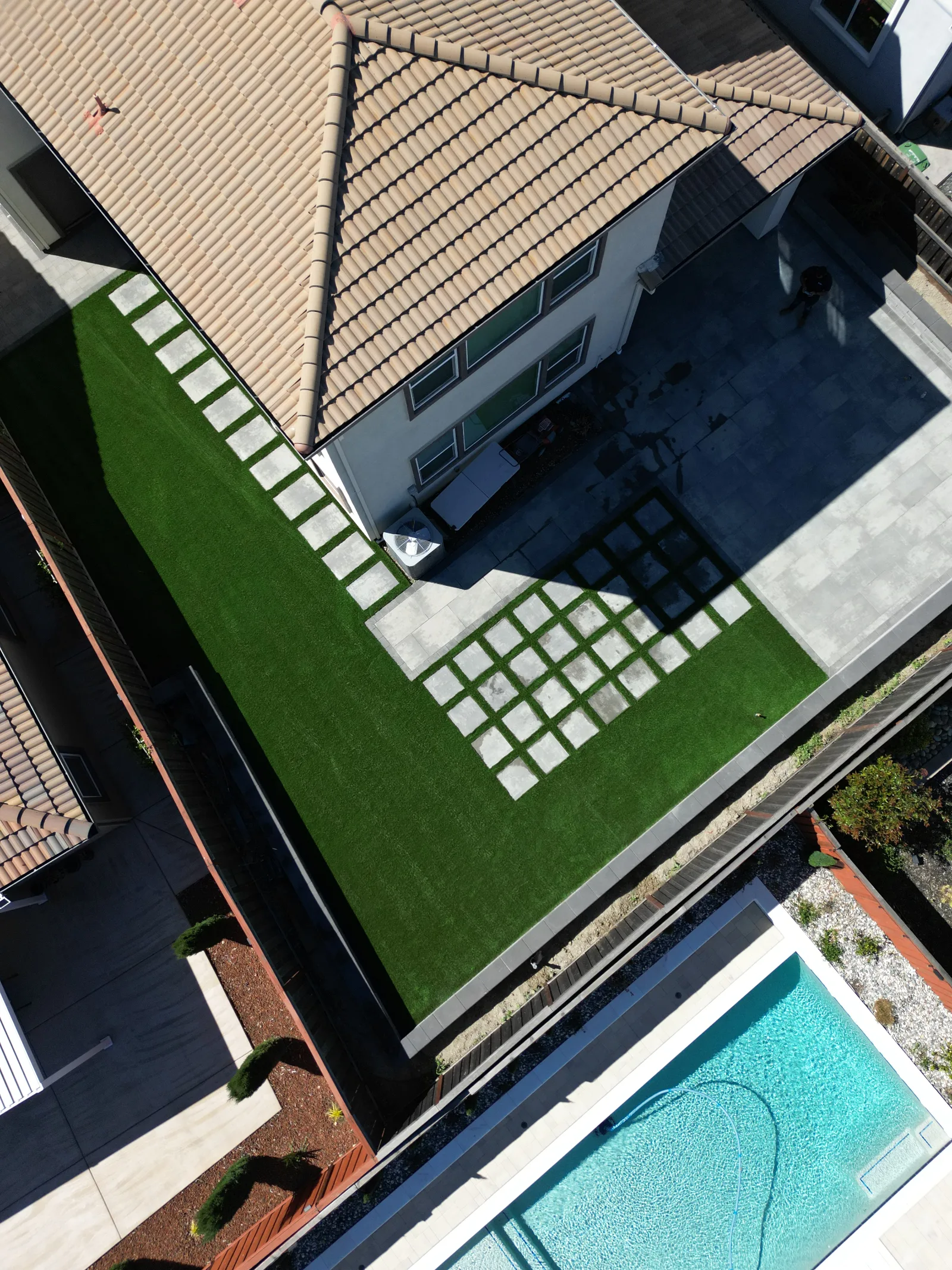 Aerial drone view of a paver patio with artificial turf installed by Royal Outdoor Solutions in Fairfield, California