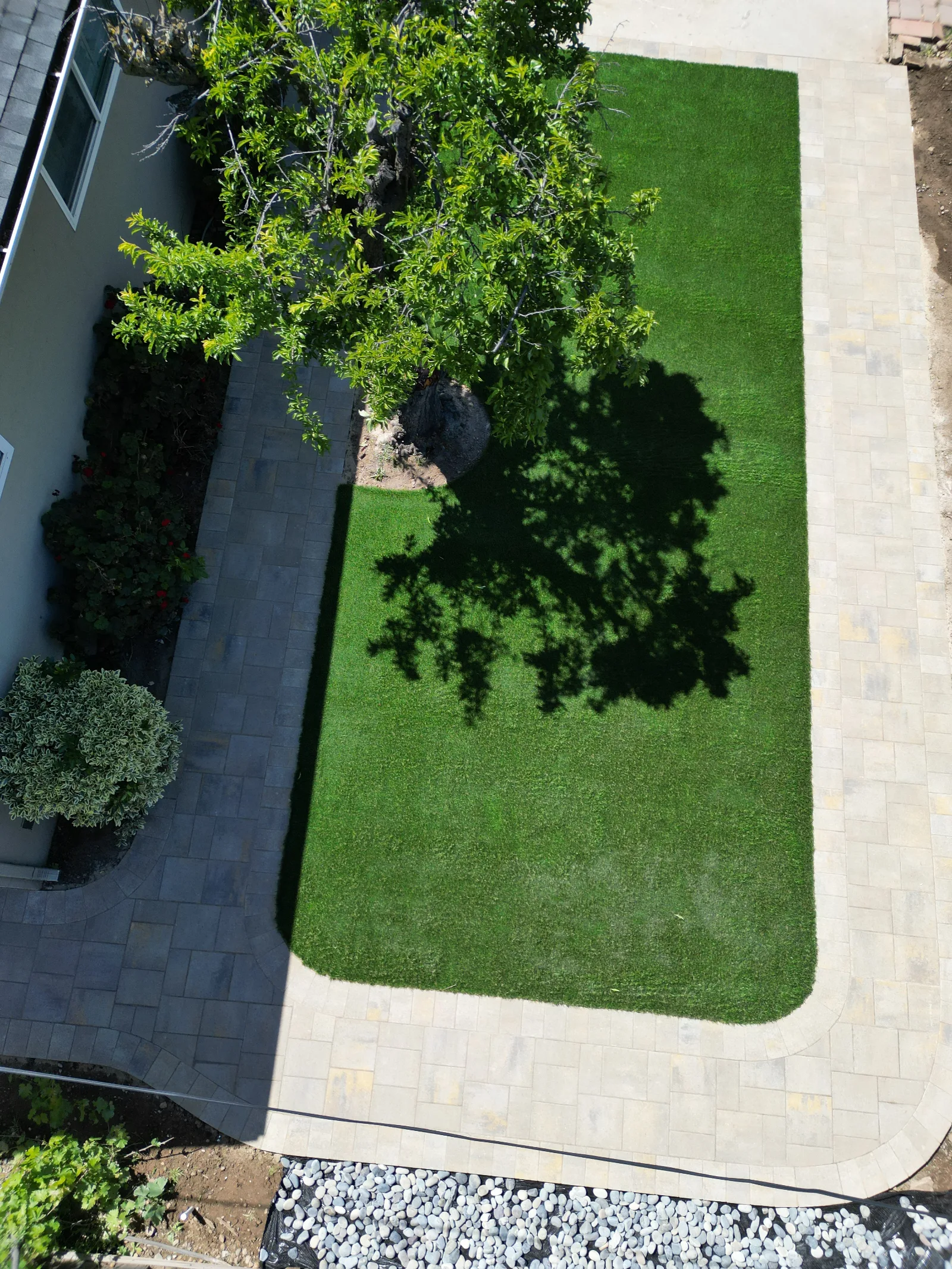Side aerial view of paver patio and turf grid installation with pool in background, Fairfield, CA